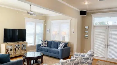 a living room with a blue couch and a tv at Take It Eeaasy in Panama City Beach
