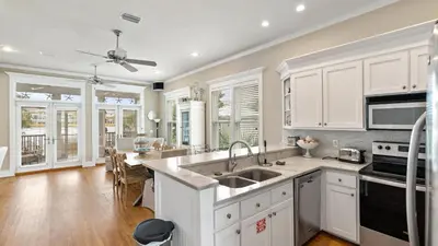 a kitchen with white cabinets and a sink at Take It Eeaasy in Panama City Beach