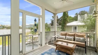 a screened porch with a couch and a table at Take It Eeaasy in Panama City Beach
