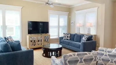 a living room with two blue couches and a tv at Take It Eeaasy in Panama City Beach