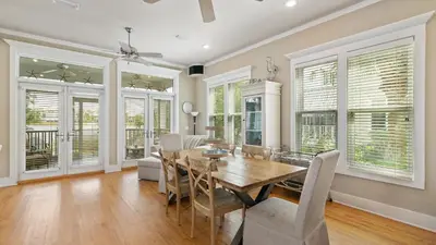 a dining room with a table and chairs and windows at Take It Eeaasy in Panama City Beach