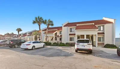 two cars parked in a parking lot in front of a building at Latitude 29 Unit 22 in Panama City Beach