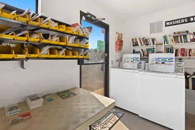 a room with a table and a shelf with books at Latitude 29 Unit 22 in Panama City Beach