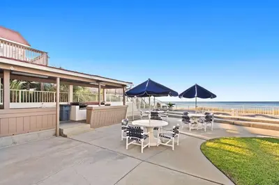 a patio with a table and chairs and umbrellas at Latitude 29 Unit 22 in Panama City Beach