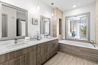a bathroom with two sinks and a tub and two mirrors at The Pointe 333 in Inlet Beach