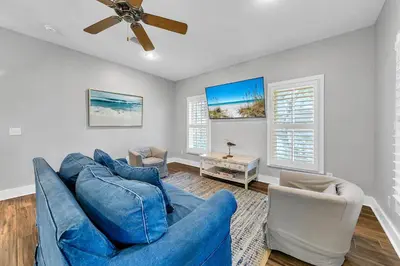 a living room with a blue couch and two chairs at The Grey Gull in Inlet Beach