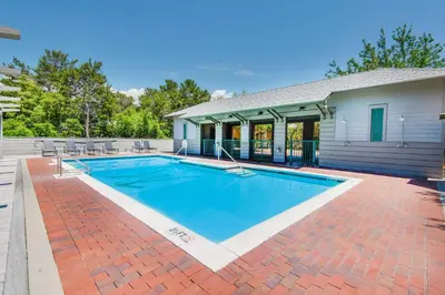 a swimming pool in front of a house at The Grey Gull in Inlet Beach