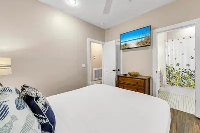 a white bedroom with a bed and a window at The Grey Gull in Inlet Beach
