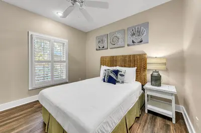 a bedroom with a large bed and a window at The Grey Gull in Inlet Beach