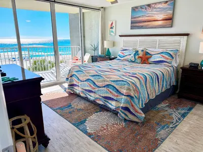a bedroom with a bed with a view of the ocean at Mermaid's Delight - PCB, FL in Panama City Beach