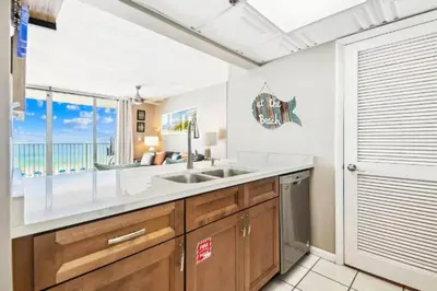a kitchen with a sink and a view of the ocean at Mermaid's Delight - PCB, FL in Panama City Beach