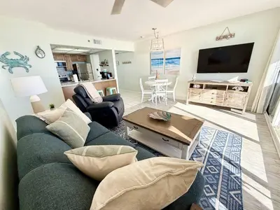 a living room with a blue couch and a tv at Mermaid's Delight - PCB, FL in Panama City Beach