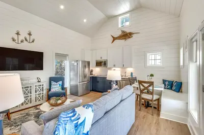 a living room with a couch and a kitchen at Margaritas and Parrots in PCB Beachy Bungalow! in Panama City Beach