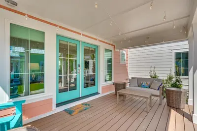 a porch with a bench and windows on a house at Margaritas and Parrots in PCB Beachy Bungalow! in Panama City Beach
