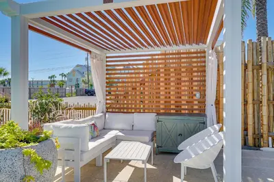 a pergola with a couch and chairs on a patio at Margaritas and Parrots in PCB Beachy Bungalow! in Panama City Beach