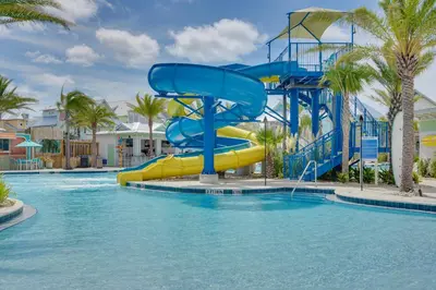 a water slide in a pool at a resort at Margaritas and Parrots in PCB Beachy Bungalow! in Panama City Beach
