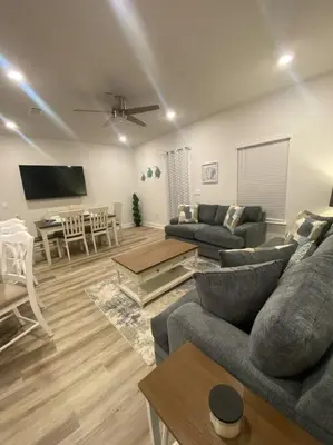 a living room with a couch and a table at PCB Townhome in Panama City Beach