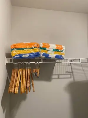 a shelf with a bunch of towels and wooden bats at PCB Townhome in Panama City Beach