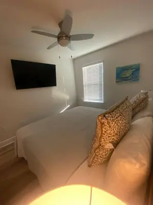 a bedroom with a bed with a ceiling fan at PCB Townhome in Panama City Beach