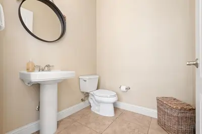 a bathroom with a toilet and a sink and a mirror at Seeking Sunsets 30A in Rosemary Beach