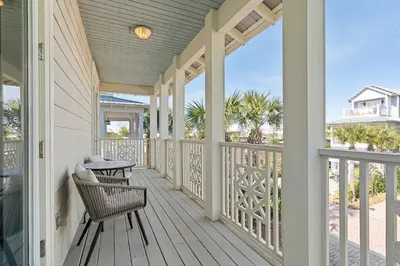 a porch with a table and chairs on it at Seeking Sunsets 30A in Rosemary Beach