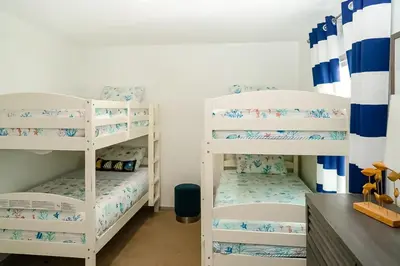 two white bunk beds in a small room at Boat Dock! Canal-Front Family Retreat in PCB in Panama City Beach