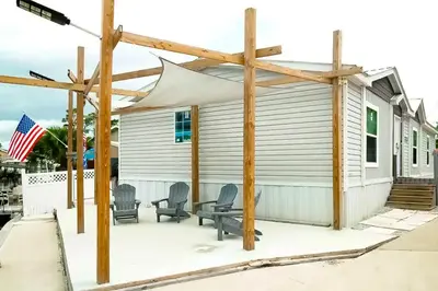 a covered patio with chairs and a building at Boat Dock! Canal-Front Family Retreat in PCB in Panama City Beach
