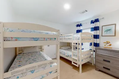 a bedroom with two bunk beds and a desk at Boat Dock! Canal-Front Family Retreat in PCB in Panama City Beach