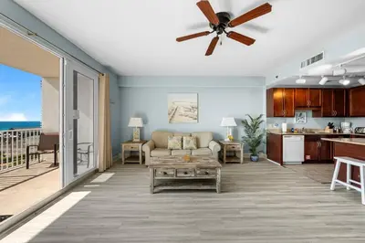 a living room with a couch and a ceiling fan at Oceanview Family Friendly Resort Low Floor Condo! Steps 2 Beach! by Dolce Vita Getaways PCB in Panama City Beach