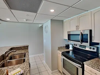 a kitchen with a sink and a stove top oven at Edgewater Tower III #708 in Panama City Beach