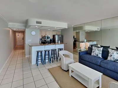 a living room with a blue couch and a kitchen at Edgewater Tower III #708 in Panama City Beach