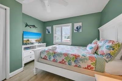 a bedroom with green walls and a bed and a window at Coastal Bliss in Panama City Beach