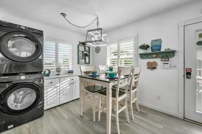 a kitchen with a table and a washing machine at Coastal Bliss in Panama City Beach