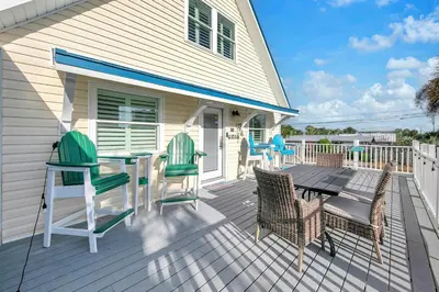 a deck with chairs and a table on a house at Coastal Bliss in Panama City Beach
