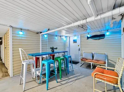 a patio with a table and chairs and a bench at Coastal Bliss in Panama City Beach