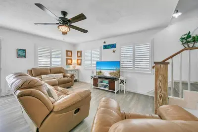 a living room with couches and a flat screen tv at Coastal Bliss in Panama City Beach
