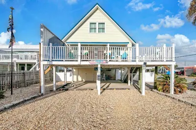 a house with a large deck in front of it at Coastal Bliss in Panama City Beach