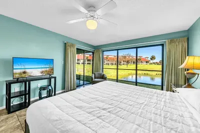 a bedroom with a large bed and a large window at Edgewater Golf Villa 3101 in Panama City Beach