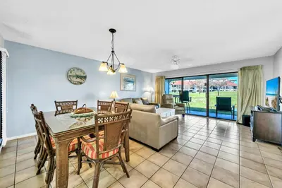 a living room with a table and a couch at Edgewater Golf Villa 3101 in Panama City Beach