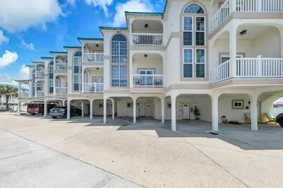 a large white building with balconies on a street at The Palms A3 in Panama City Beach