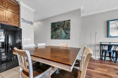a kitchen and dining room with a wooden table and chairs at The Palms A3 in Panama City Beach