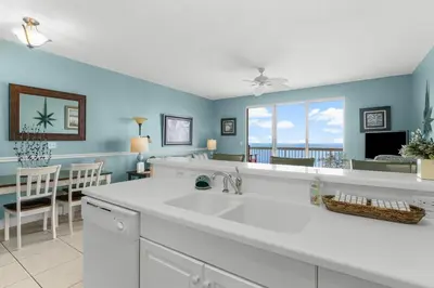a kitchen with a white sink and a dining room at Celadon #2106 in Panama City Beach