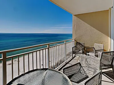 a balcony with chairs and a table and the ocean at Emerald Beach #1032 in Panama City Beach