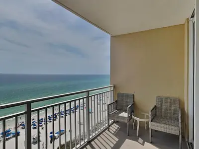 a balcony with two chairs and a table and the ocean at Emerald Beach #1032 in Panama City Beach
