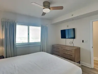 a bedroom with a bed and a flat screen tv at Emerald Beach #1032 in Panama City Beach