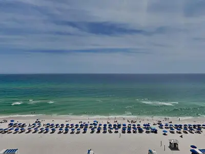 a beach with many umbrellas and the ocean at Emerald Beach #1032 in Panama City Beach