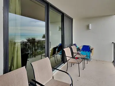 a room with chairs and a balcony with a view of the ocean at Edgewater Tower II #209 in Panama City Beach