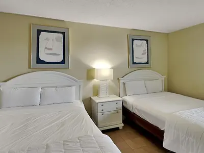 a hotel room with two beds and a lamp at Edgewater Tower II #209 in Panama City Beach