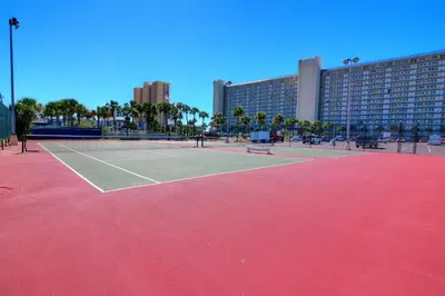 a tennis court in front of a large building at Summit Beach Resort #222 in Panama City Beach