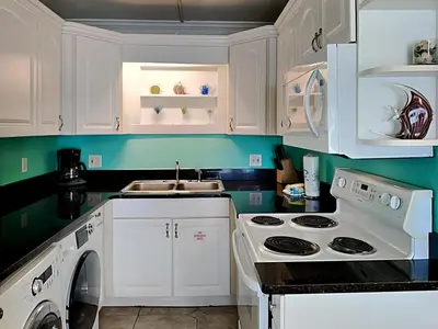 a kitchen with white cabinets and a white stove top oven at Summit Beach Resort #222 in Panama City Beach